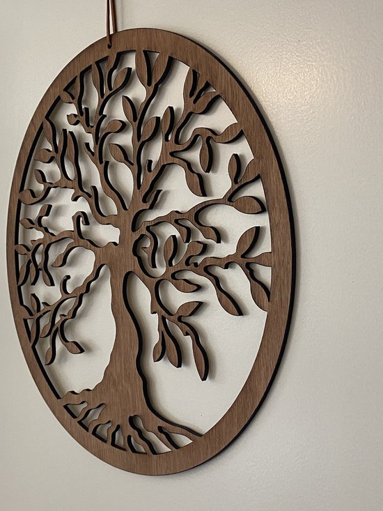 Décoration murale ronde en bois marron d'un arbre de vie, présentée sur un mur blanc.