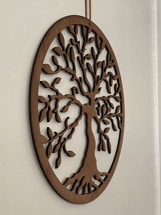 Décoration murale ronde en bois marron d'un arbre de vie, présentée sur un mur blanc.