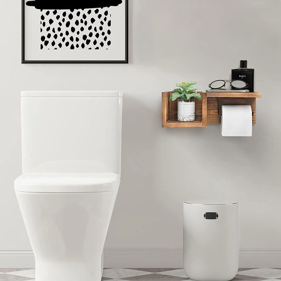 Houten toiletrolhouder met plank boven een witte prullenbak en naast een toilet, met kleine plant, bril en parfumfles.
