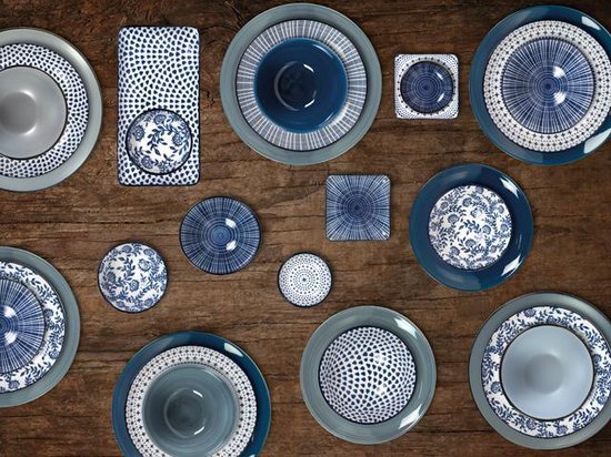 Gusta servies met blauw-witte patronen op een houten ondergrond.