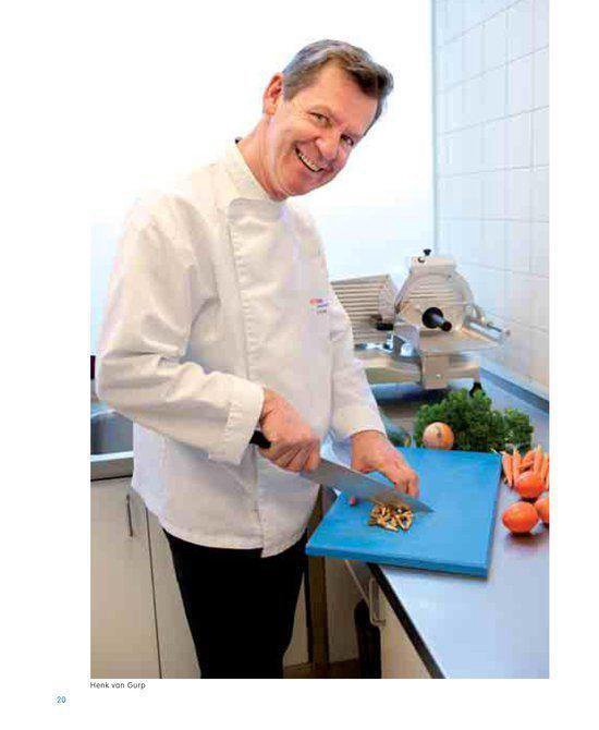 Chef-kok Henk van Gurp snijdt ingrediënten op een blauwe snijplank.