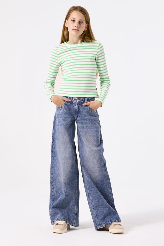 Meisje in groen gestreept shirt met lange mouwen en wijde jeans.