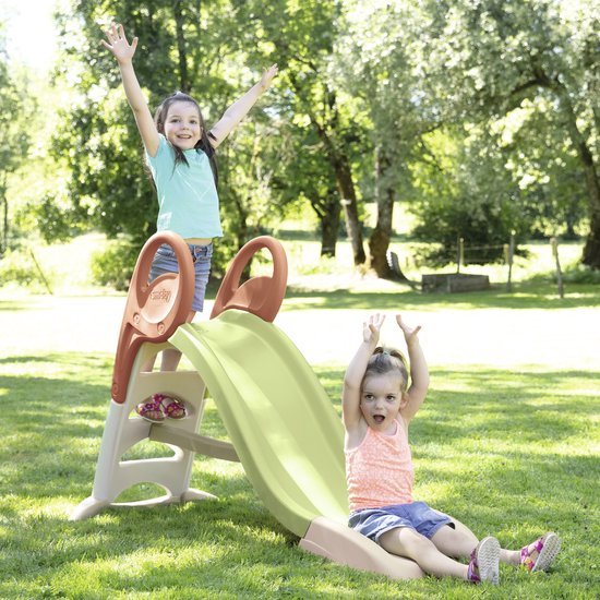 Twee blije kinderen spelen op de groene en beige Smoby KS glijbaan in de tuin.