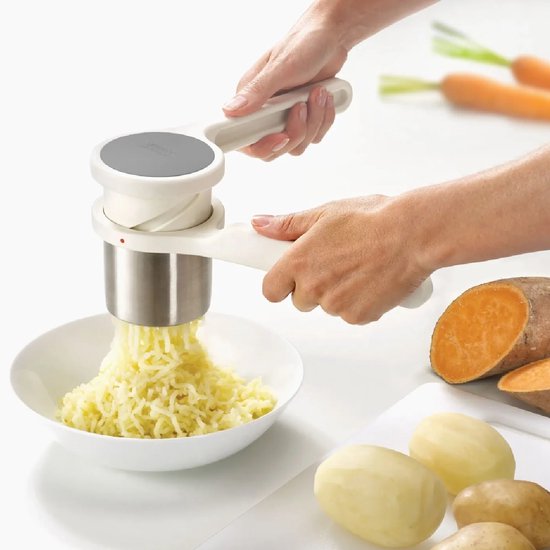 Witte Helix aardappelpers in gebruik, die aardappelen tot slierten perst in een witte kom.