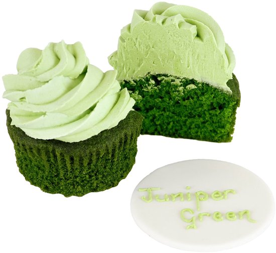 Een cupcake met lichtgroene toef en een andere cupcake doormidden gesneden. Beide tonen donkergroene cake. Naast hen ligt een ronde witte decoratie met 'Juniper Green' erop.