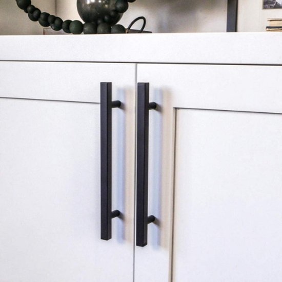 Deux poignées noires carrées en acier inoxydable avec un entraxe de 128 mm sur des portes d'armoires de cuisine blanches.