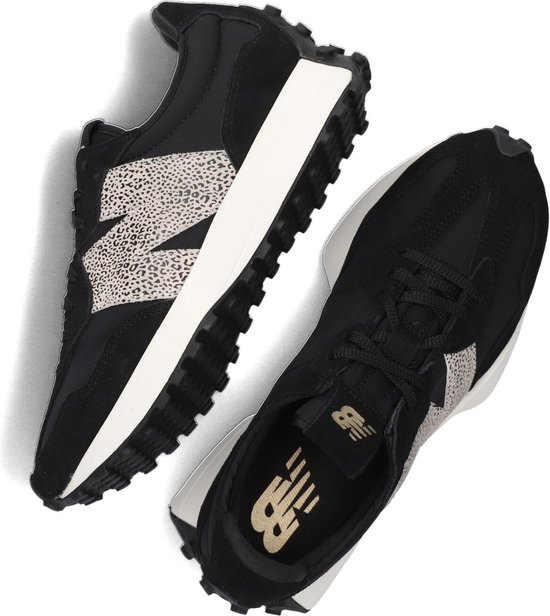 Een paar zwarte New Balance 327 sneakers met beige luipaardprint N-logo en witte zolen.