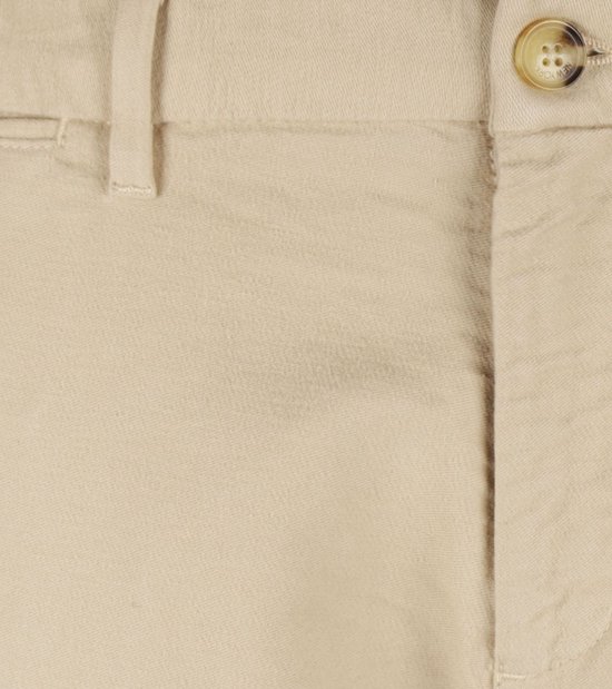Detail van de knoopsluiting van een crèmekleurige chino broek van moleskin.