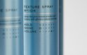 Close-up van een blauwe REF textuursprayfles met tekst over hold, shine en volume.