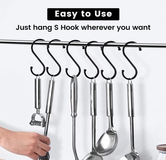 Zwarte S-haken hangen aan een stang met keukengerei eraan. Een hand pakt een van de haken.