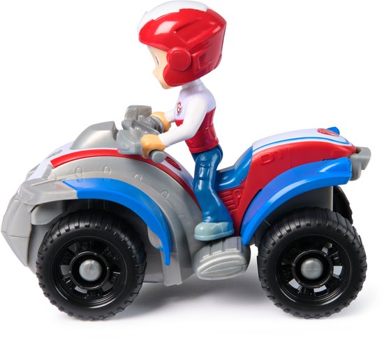 Zijaanzicht van Ryder op zijn rode, witte en blauwe quad. Hij draagt een rode helm en een wit shirt met rode accenten.