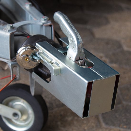 Zilverkleurig disselslot met een roestvrijstalen hangslot, gemonteerd op een aanhangwagenkoppeling.