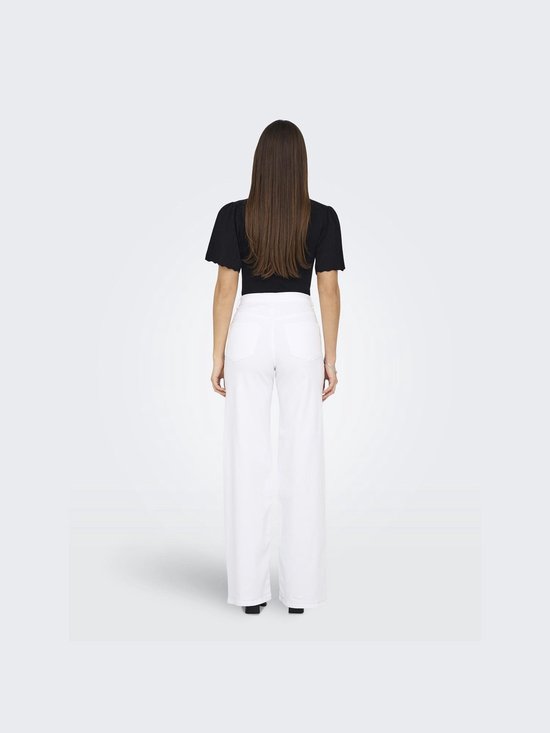Model van achteren gezien in wijde, witte jeans en zwart topje met korte, pofmouwen.
