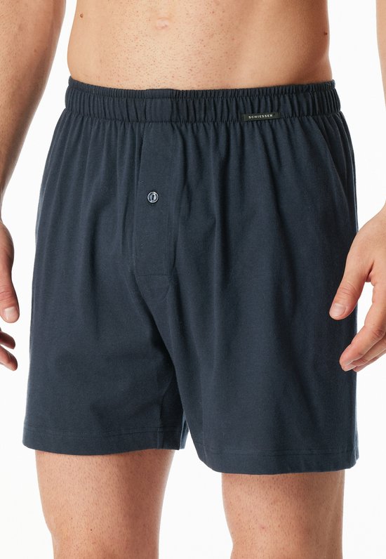 Donkerblauwe boxesshorts met elastische tailleband, knoopsluiting en Schiesser-label.