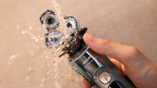 Philips Shaver i9000 Prestige Ultra wordt schoongespoeld onder de kraan.