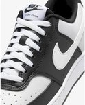 Close-up van de voorkant van een witte en zwarte Nike Court Vision Low sneaker met witte veters en een witte swoosh.