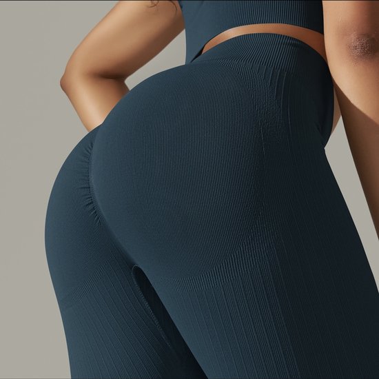 Detail van de blauwgrijze legging met ribbeltextuur, met accent op de textuur en pasvorm.