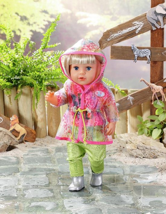 Pop met blonde bob, in regenjas met luipaardprint, knalgroene broek en zilveren laarsjes.