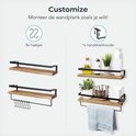 Houten wandplanken met zwarte frames, getoond met haakjes en handdoekhouder configuraties.