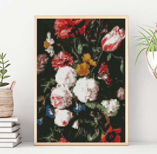 Peinture diamant de fleurs dans un vase avec cadre doré, posée sur une étagère blanche.