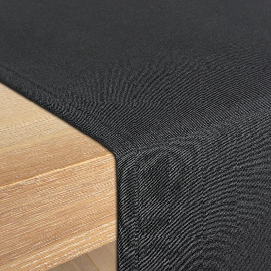 Detail van een zwarte tafelloper op een houten tafel.
