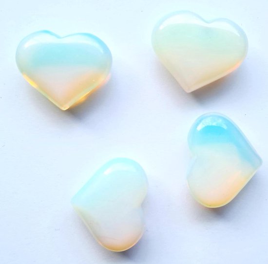 Vier witte opalieten harten met blauwe en oranje gloed op witte achtergrond.