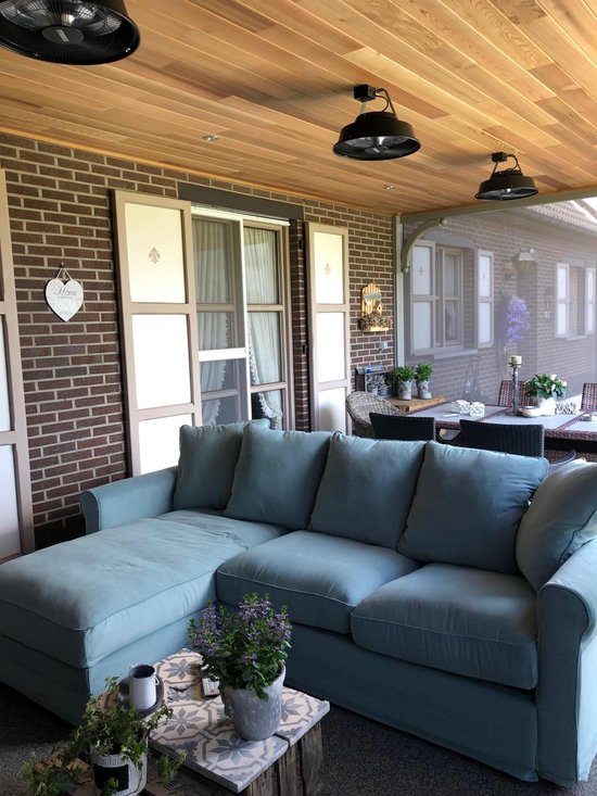 Houten plafond met drie zwarte hangende ventilatoren, naast een lichtblauwe loungeset.