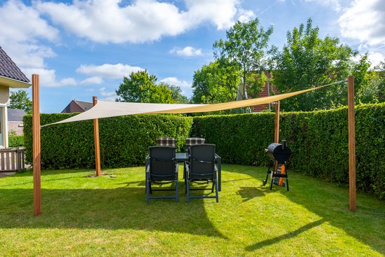 Een beige rechthoekig schaduwdoek hangt over een tuintafel met vier stoelen en een barbecue.