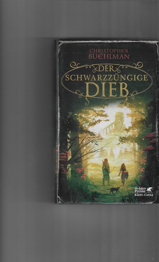 Boekomslag 'Der schwarzzüngige Dieb' met een fantasy-bosscène, twee avonturiers en een kat bij zonsopgang.