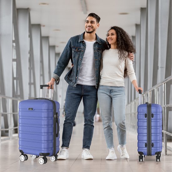 Man en vrouw, beide met een blauwe Voyageux reiskoffer, lopen samen door een moderne gang.