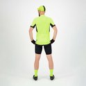 Man in fluorgeel fietsshirt met korte mouwen en zwarte accenten, zwarte broek en sokken. Zicht op de achterkant.