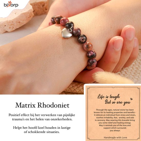 Een pols gedragen roze en bruine kralenarmband met hartvormige hanger.
