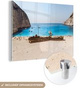 MuchoWow® Glasschilderij 120x90 cm - Schilderij acrylglas - Schipwrak op het strand - Foto op glas - Schilderijen