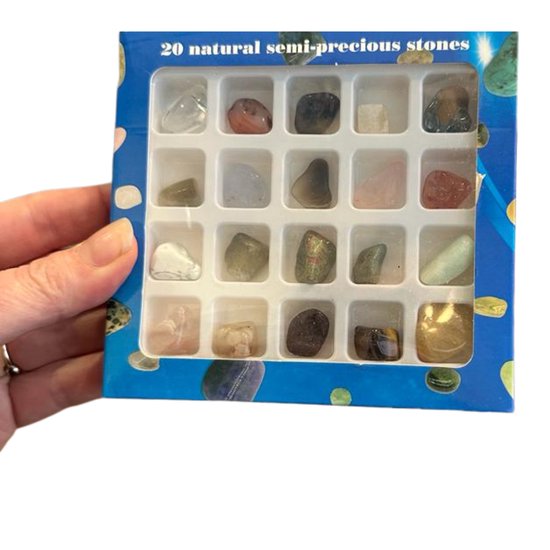 Hand houdt een doos open met 20 'natural semi-precious stones' in een bakje.