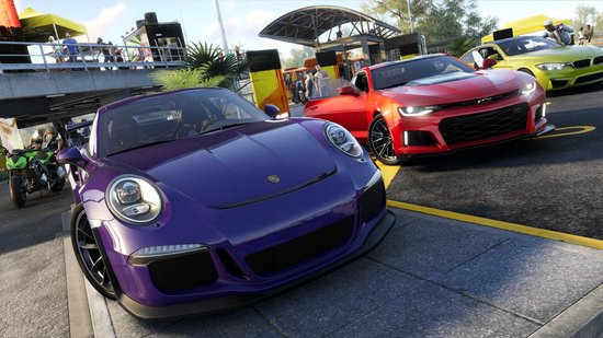 Paarse sportwagen op de voorgrond, met rode en gele sportwagens en een groene motor op de achtergrond.