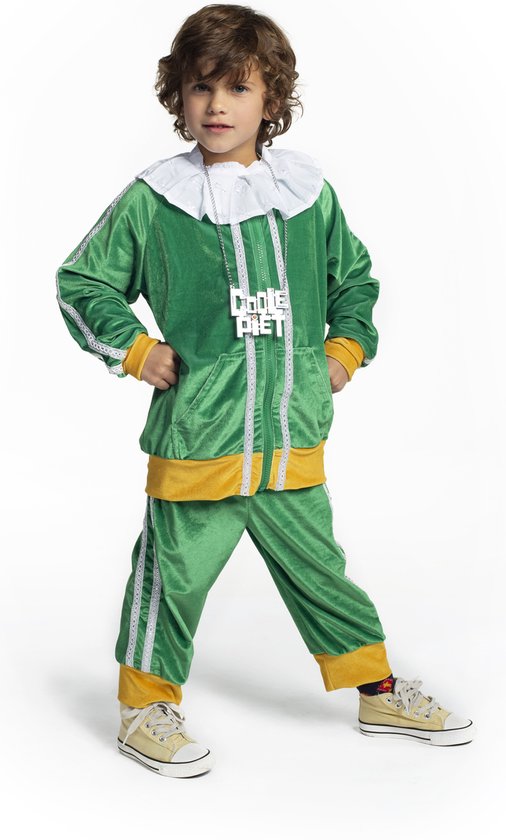 Jongen in een groen fluwelen trainingspak met gele accenten, witte ruchekraag en een zilverkleurige ketting met 'COOLE PIET'.