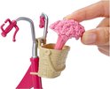 Hand voegt roze bloemen toe aan rieten mandje op roze Barbie fiets.
