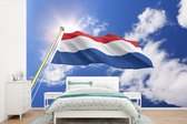 Behang - Fotobehang De vlag van Nederland wappert in de lucht - Breedte 390 cm x hoogte 260 cm