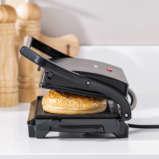 Zwarte Tristar contactgrill met een belegd broodje met sesamzaad erin.