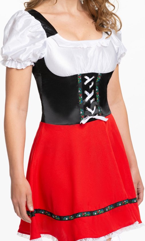 Model in een zwart korset met witte veters en een rode rok met bloemenprint.