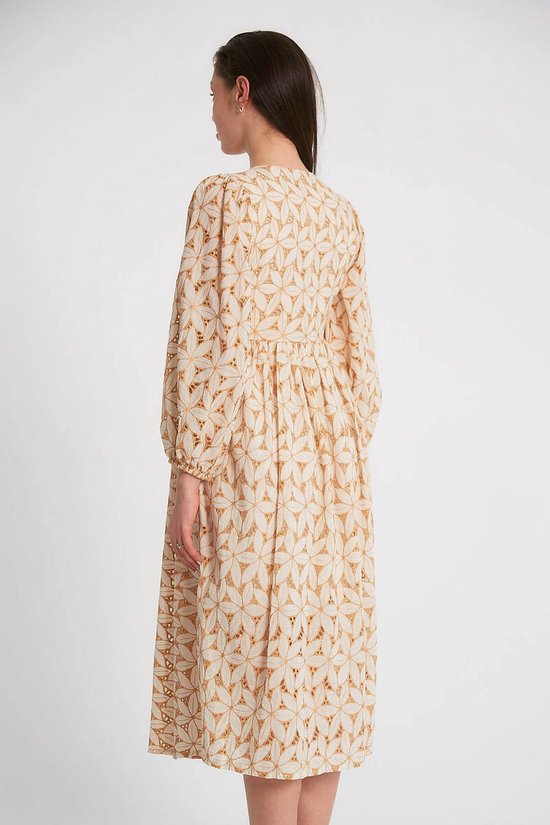 Achterkant van crèmekleurige jurk met lange, pofmouwen en camel geometrisch patroon.