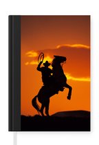 Notitieboek - Schrijfboek - Silhouet van cowboy op paard die steigert - Notitieboekje klein - A5 formaat - Schrijfblok