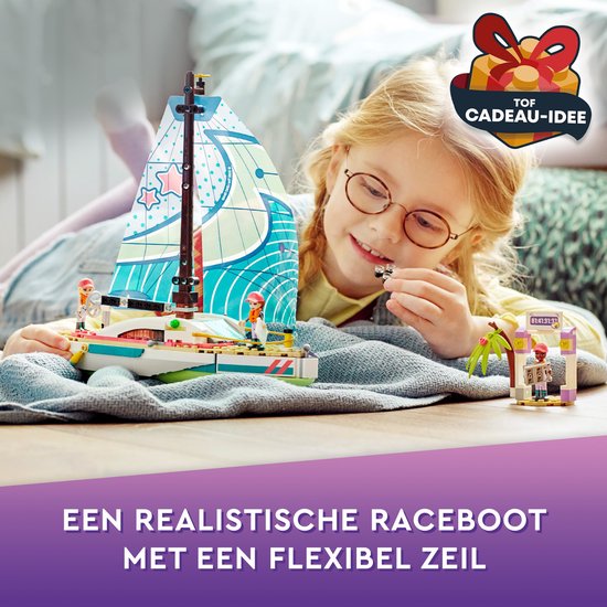 Kind met bril speelt met een felgekleurde LEGO zeilboot met bedrukt zeil met sterren en golven.