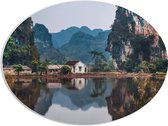 WallClassics - PVC Schuimplaat Ovaal - Huisje bij Water en Bergen - Vietnam - 68x51 cm Foto op Ovaal  (Met Ophangsysteem)