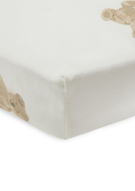 Drap housse crème avec un imprimé ours en peluche couleur sable, détail du coin.
