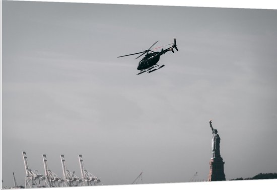 WallClassics - PVC Schuimplaat- Helikopter zwevend boven Vrijheidsbeeld in New York - 150x100 cm Foto op PVC Schuimplaat