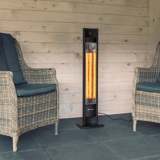 Zwarte staande terrasverwarmer met gloeiende rode elementen, tussen twee rieten stoelen.