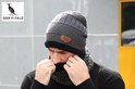 Man met donkergrijze wintermuts en col, met bijpassende gebreide sjaal.