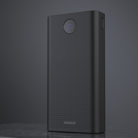 Zwarte Phreeze powerbank met een gestippeld patroon en een digitaal display met '100', op een marmeren ondergrond.