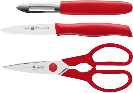 Set van een rood aardappelschilmesje, een rood keukenmes en een rode keukenschaar.